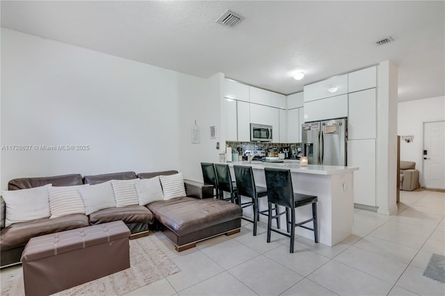 living room with a textured ceiling and light tile patterned floors