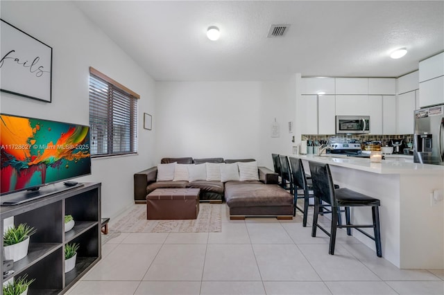 living room featuring a textured ceiling and light tile patterned flooring