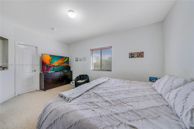 bedroom featuring light carpet and a textured ceiling