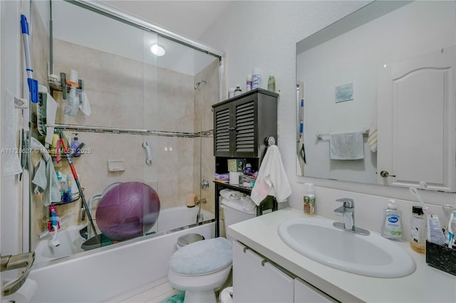 full bathroom featuring toilet, vanity, and shower / bath combination with glass door