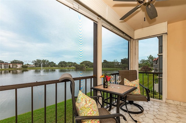 sunroom / solarium featuring ceiling fan and a water view