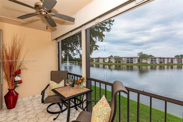 sunroom / solarium with a water view and ceiling fan