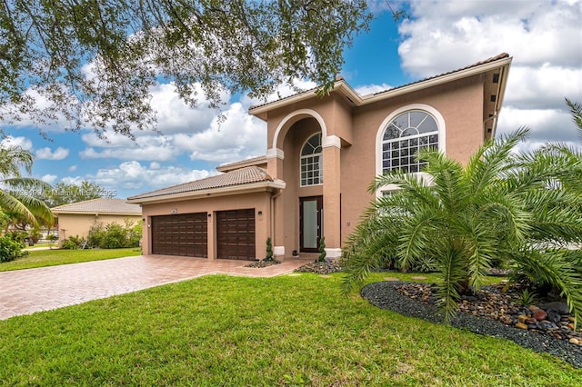 mediterranean / spanish home featuring a garage and a front lawn