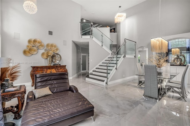 stairway with an inviting chandelier and a high ceiling