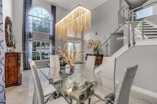 dining room featuring a towering ceiling