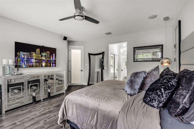 bedroom with hardwood / wood-style flooring, a textured ceiling, and ceiling fan