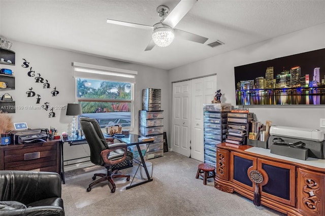 home office featuring ceiling fan, light colored carpet, and a textured ceiling