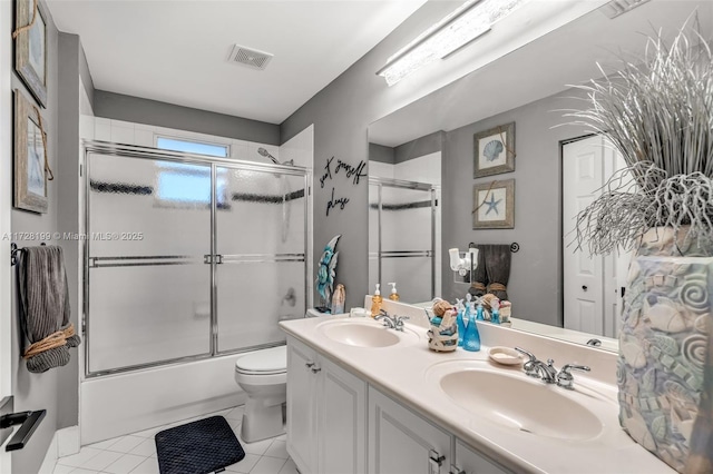 full bathroom featuring enclosed tub / shower combo, vanity, toilet, and tile patterned floors