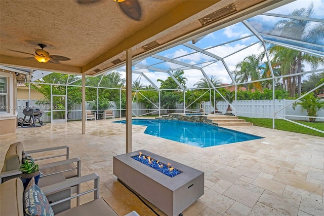 view of swimming pool with a patio, a lanai, and a fire pit