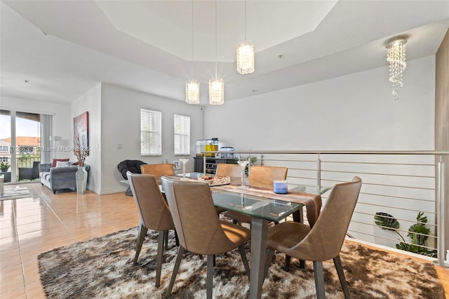 tiled dining space with a tray ceiling