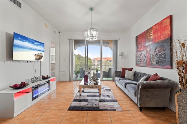 tiled living room with a notable chandelier