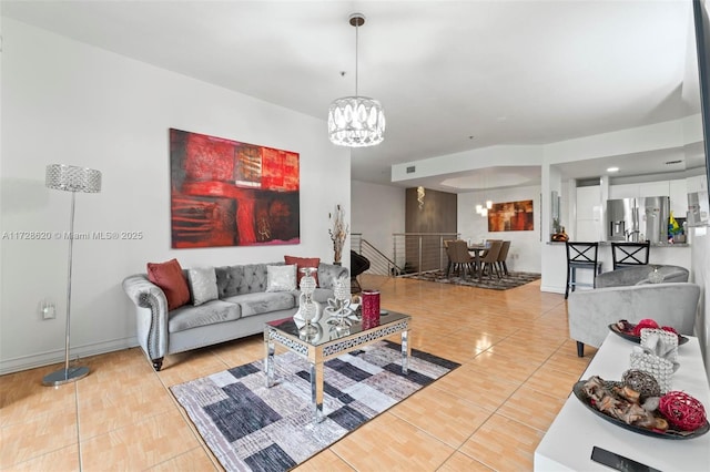 tiled living room with a notable chandelier