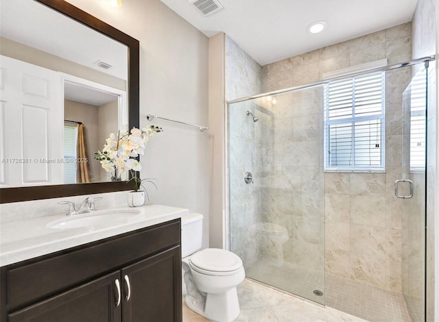 bathroom featuring a shower with shower door, tile patterned floors, toilet, and vanity