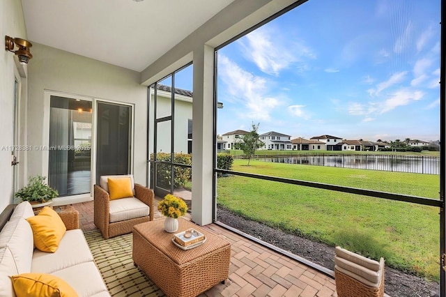 sunroom featuring a water view