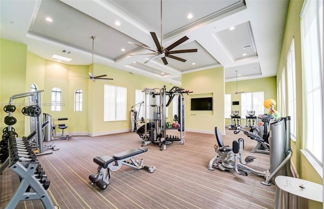 exercise room with ceiling fan, a towering ceiling, and coffered ceiling