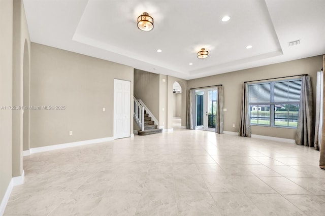 spare room featuring a raised ceiling and french doors