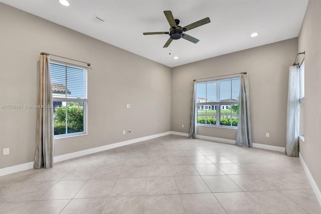 spare room featuring ceiling fan, plenty of natural light, and light tile patterned floors