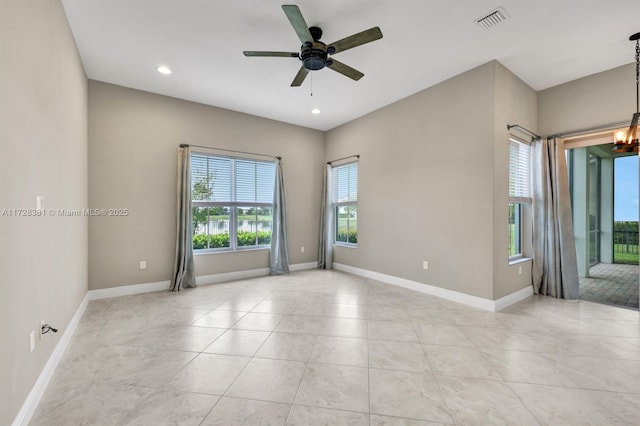 unfurnished room featuring ceiling fan with notable chandelier