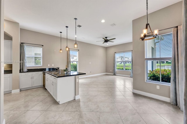 kitchen featuring ceiling fan with notable chandelier, pendant lighting, white cabinets, kitchen peninsula, and light tile patterned floors