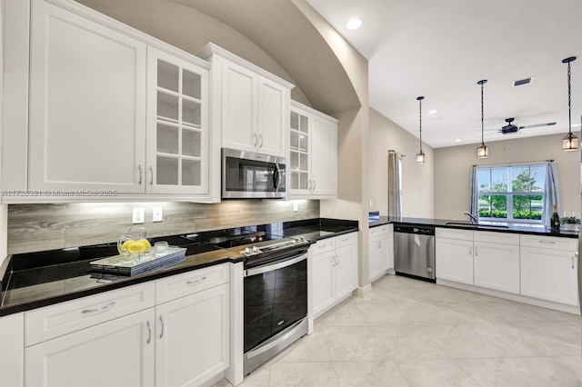 kitchen featuring white cabinetry, ceiling fan, stainless steel appliances, backsplash, and decorative light fixtures