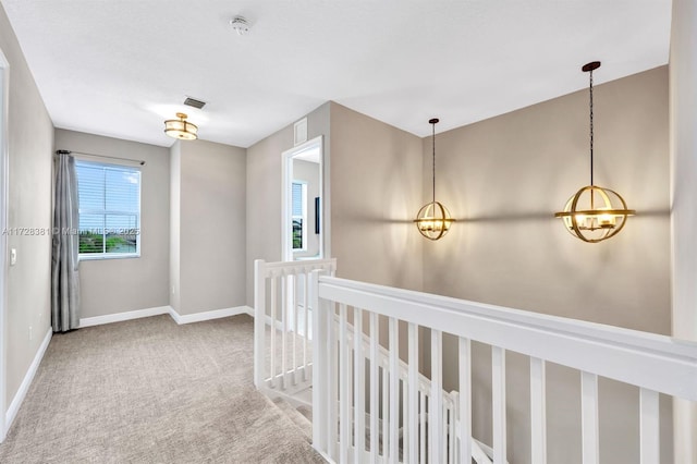 hallway featuring a chandelier and carpet floors