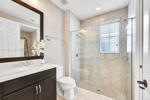 bathroom featuring toilet, tile patterned floors, a shower with shower door, and vanity