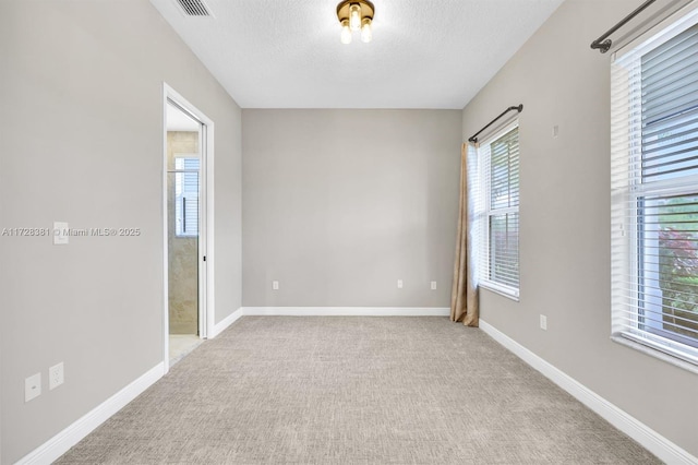 carpeted spare room with a textured ceiling