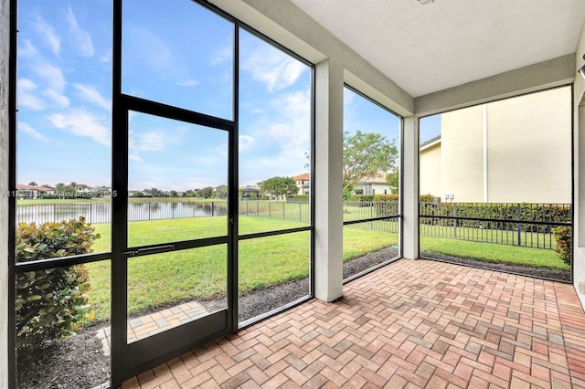 unfurnished sunroom featuring a water view