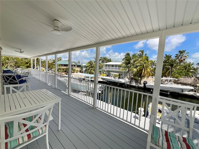 deck with a ceiling fan and a water view