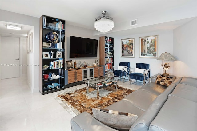 living room featuring light tile patterned floors, visible vents, and a chandelier