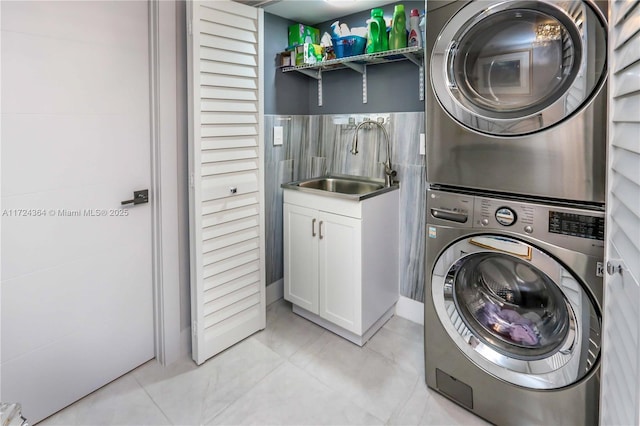 laundry area featuring a sink, cabinet space, and stacked washer and dryer