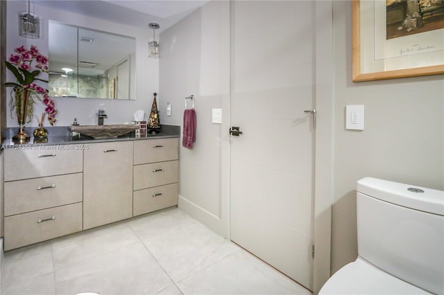 bathroom with tile patterned flooring, vanity, and toilet