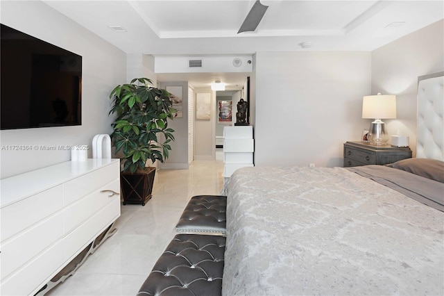 bedroom featuring light tile patterned floors, a raised ceiling, and visible vents