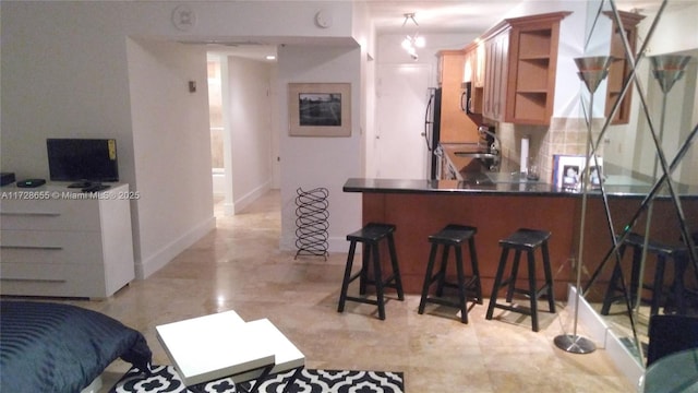 bar featuring appliances with stainless steel finishes and tasteful backsplash