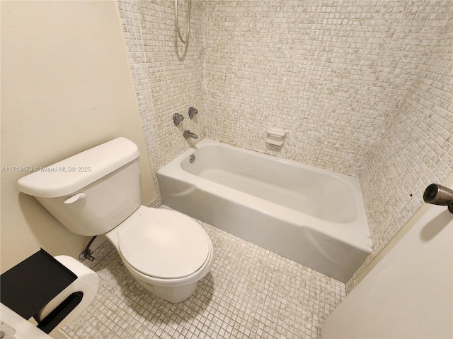 bathroom with tile patterned floors, toilet, and tiled shower / bath