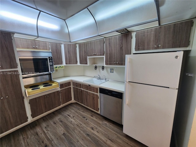 kitchen with dark hardwood / wood-style flooring, dishwasher, sink, and white refrigerator