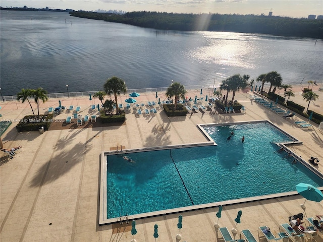 view of pool featuring a water view and a patio area