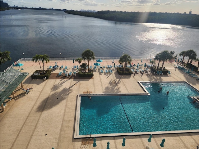 view of swimming pool featuring a water view and a patio area