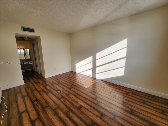 spare room with dark wood-type flooring and a textured ceiling