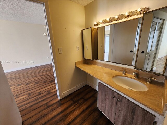 bathroom featuring a textured ceiling, hardwood / wood-style floors, and vanity