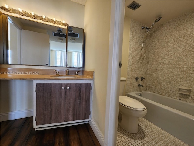 full bathroom featuring wood-type flooring, tiled shower / bath combo, vanity, and toilet