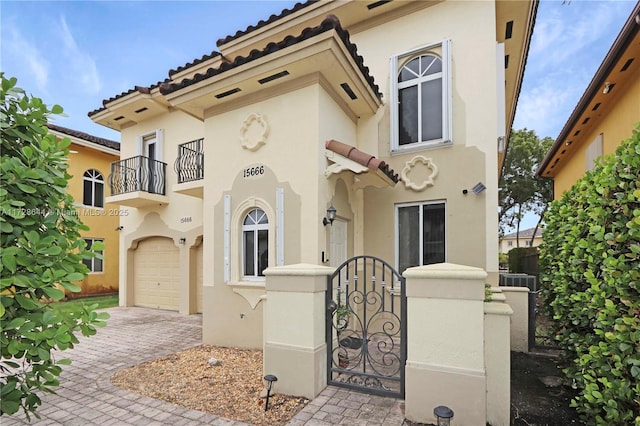 mediterranean / spanish house featuring a garage and a balcony