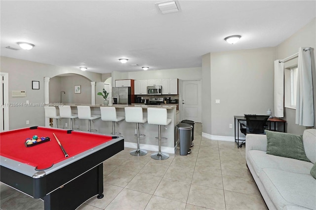 playroom with decorative columns and light tile patterned floors