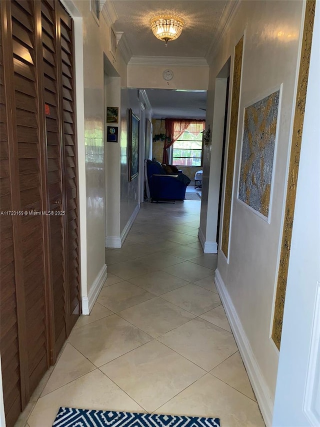 hall with light tile patterned floors and ornamental molding