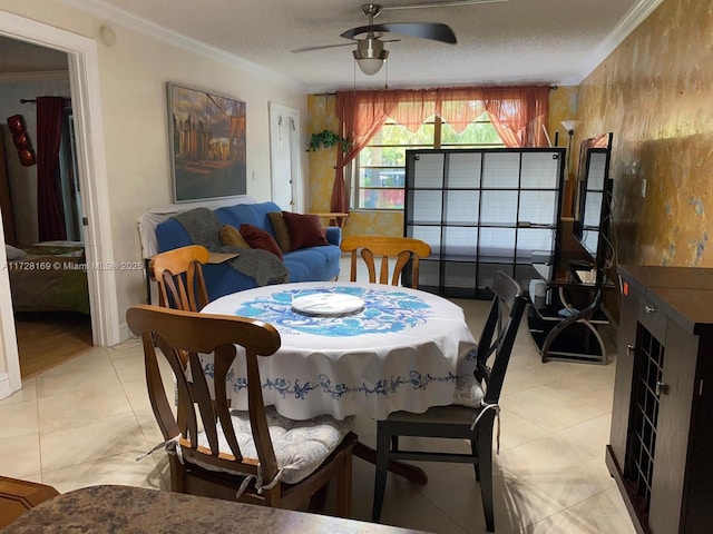 tiled dining space featuring ceiling fan, a textured ceiling, and ornamental molding