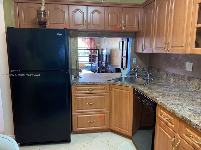 kitchen with sink, light tile patterned floors, and black appliances