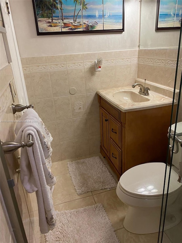 bathroom with tile walls, tile patterned floors, vanity, and toilet