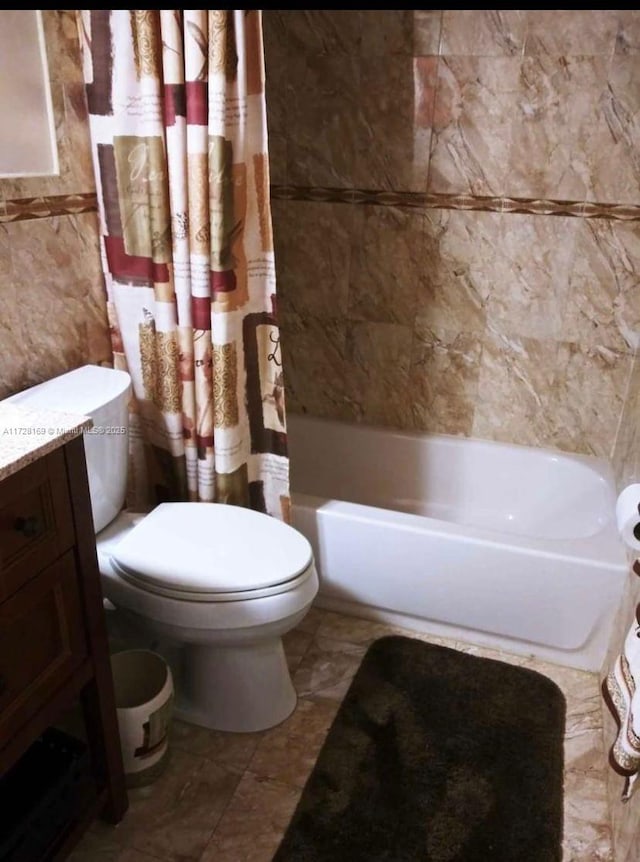 full bathroom featuring vanity, toilet, shower / bathtub combination with curtain, and tile walls