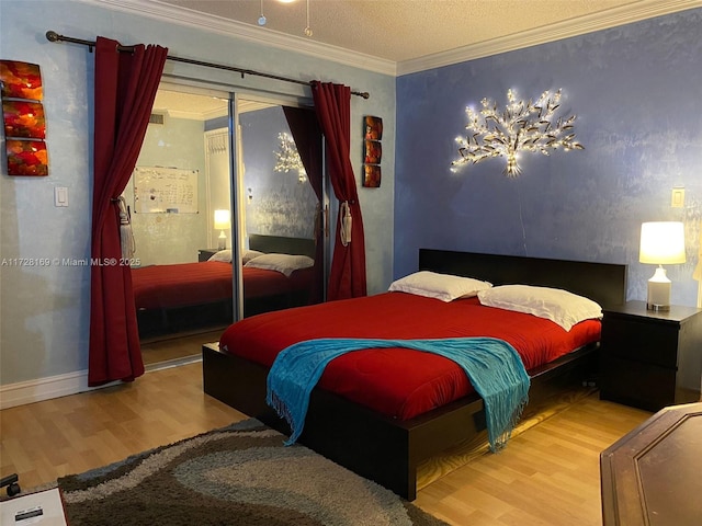 bedroom featuring a textured ceiling, ornamental molding, and hardwood / wood-style floors