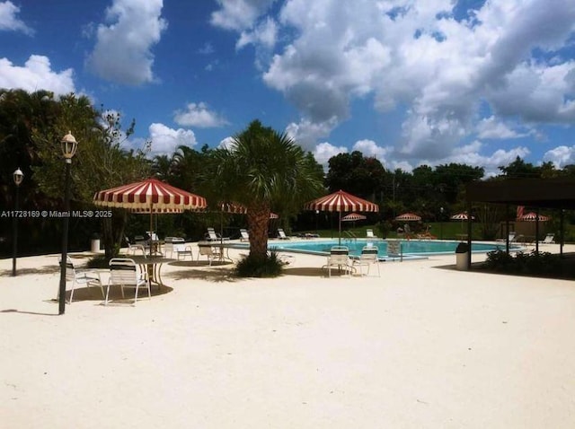 view of home's community featuring a pool and a patio